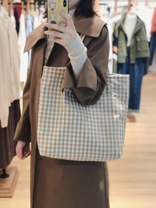 Grande borsa tote in tela a quadretti marroni e beige mostrata in un selfie allo specchio
