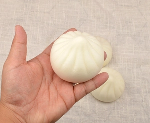 Close-up of three squishy 7cm steamed bun toys with realistic food texture and wrinkles