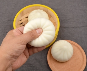 Detail of squeezing a slow rebound squishy bun toy with realistic white pleated texture