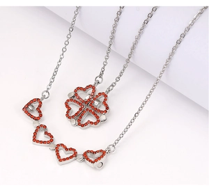 Macro shot of silver folding heart clover necklace with vibrant orange gemstones inlay