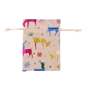 Close-up of beige linen drawstring bag with glittering reindeer and snowflake patterns