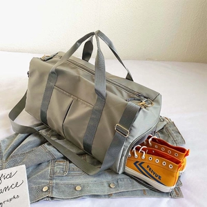 Macro shot of grey travel bag featuring an integrated side compartment for sports shoes