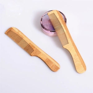 Detailed close-up of two natural bamboo combs with ergonomic handles and fine teeth texture