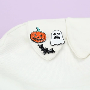 Halloween enamel pins featuring ghost and pumpkin designs on white shirt collar