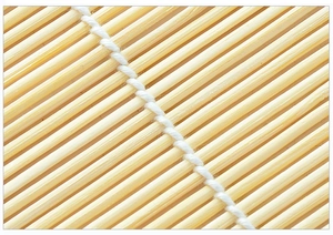 Macro shot of bamboo sushi rolling mat showing detailed natural texture and white cotton weaving