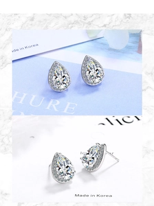 Macro shot of silver teardrop stud earrings featuring pear-shaped clear zircon stones