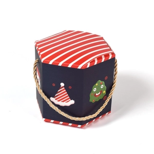 Hexagonal Christmas gift box with festive patterns and golden handle on white background