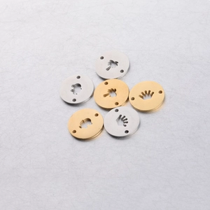 Detailed view of gold and silver stainless steel round charms with hollow patterns