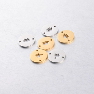 Detailed view of six gold and silver geometric charms with various hollowed-out icons