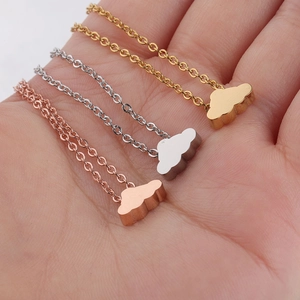 Cloud pendant necklaces in gold, silver, and rose gold finishes on a palm