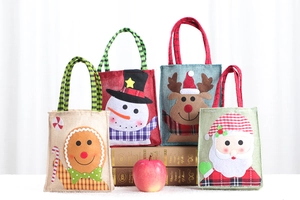 Detailansicht von vier Weihnachts-Geschenktüten aus Sackleinen mit Nikolaus und Schneemann