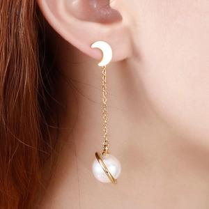 Boucles d'oreilles lune et planète en perles et acier titane portées par un modèle