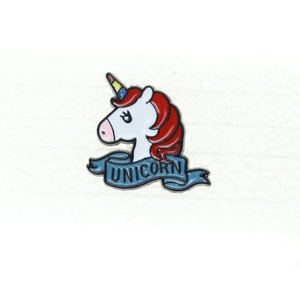 Detail of cartoon unicorn enamel pin with rainbow horn and blue Unicorn banner text