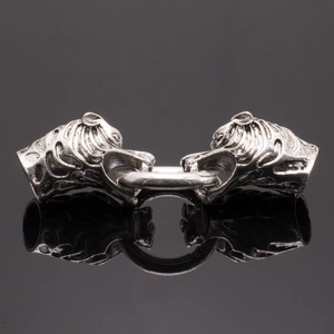 Détail d'un fermoir de bijoux tête de tigre en argent vintage avec anneau métallique sur noir