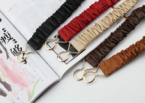 Detail of five-color elastic waist belts with cloud pleats and gold interlaced buckles