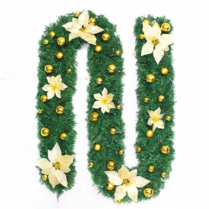 Close-up of 2.7m green Christmas garland with gold ornaments and poinsettia flowers