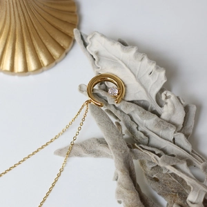 Close-up of crescent moon pendant in 18K gold-plated steel with a sparkling zircon stone