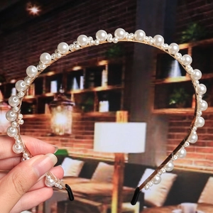 Close-up of pearl headband with woven gold wire detail and protective black end caps