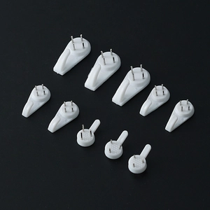 Set of various sized white non-marking wall hooks for frames and clocks on black background