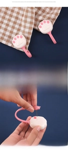 Detailed view of pink cat paw quilt clips with soft silicone pins on checked fabric