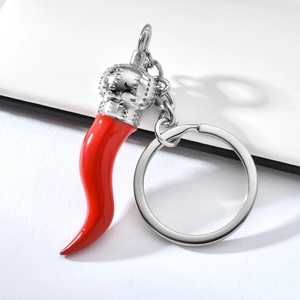 Macro shot of red chili pendant keychain with silver crown detail and polished finish