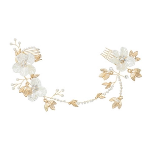Detail of bridal hair comb with gold leaves, white shell flowers, and pearls
