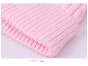 Close-up of pink cable knit texture showing detailed stitching and soft acrylic yarn
