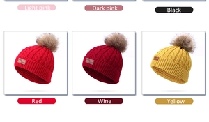Color palette display of knit cable hats with real fur pom-poms in various vibrant shades