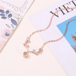 Close-up of rose gold deer antler necklace with micro-set zircons on floral background