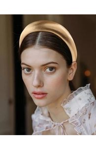 Champagne gold padded headband with metallic texture shown on a female model
