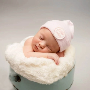 Pink knit baby beanie with Little Sister embroidery for newborn infants in soft cotton