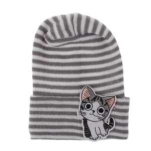 Detail of baby beanie featuring gray and white stripes with a cute cat embroidery patch