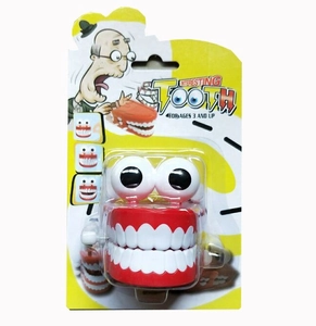 Funny wind-up jumping teeth toy with googly eyes in a blister card package