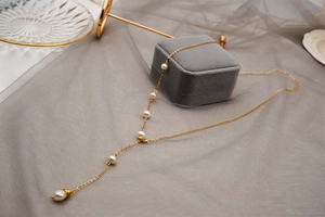Detail of adjustable gold titanium long necklace with elegant freshwater pearls