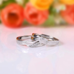 Macro shot of silver couple rings with Promise engraving and twisted crystal band