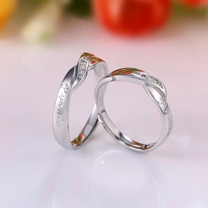Macro shot of S925 silver couple rings featuring engraved Promise text and twisted band
