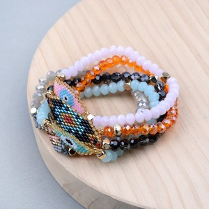 Handmade Miyuki bead bracelet set featuring vibrant Evil Eye designs on wooden base