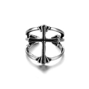 Primer plano de un anillo cruzado punk plateado vintage con acabado oxidado y relieve