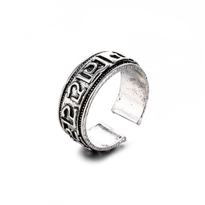 Detalle macro de anillo punk de serpiente plateado con símbolos místicos grabados y texturas