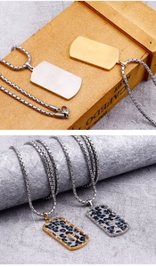 Macro shot of gold and silver stainless steel military dog tags with cross and leopard pattern