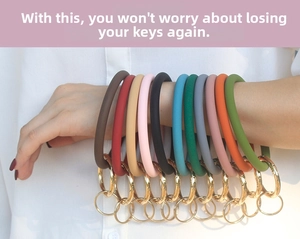 Close-up of colorful silicone ring keychains with gold metal clasps worn on the arm
