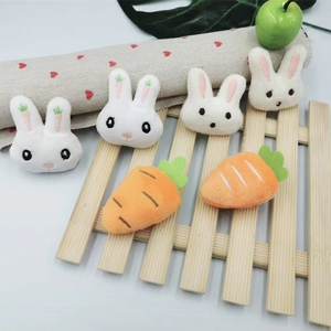 Detail of plush white rabbit and orange carrot brooch pins for DIY clothing and bags