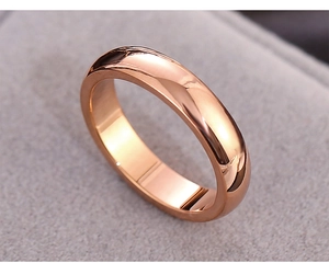 Macro shot of rose gold stainless steel ring with polished finish on gray velvet box