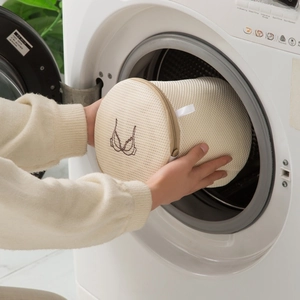 Thickened cylinder mesh laundry bag for bras being placed into a washing machine