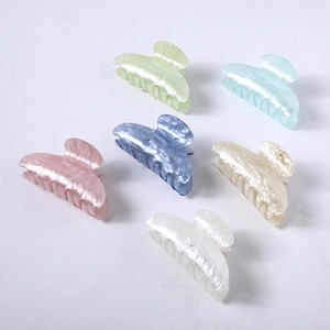 Collection of six acetate hair claws in pastel marble colors on a white background