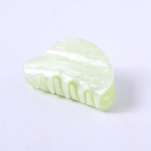 Detail of light green acetate claw clip with marbled texture and pearlescent finish