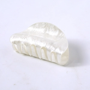 Close-up of pearl white hair claw clip with glossy acetate texture and minimalist design