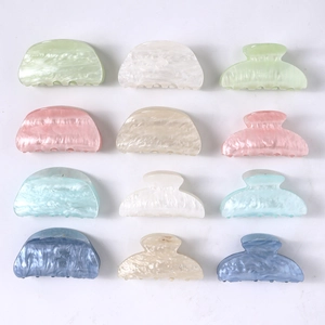 Macro shot of assorted candy-colored acetate hair claws in various shapes and marble patterns