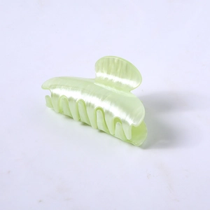 Detailed side view of a light green pearl luster hair claw clip on white background