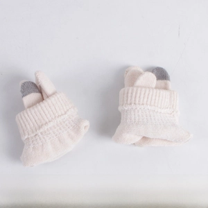 Close-up of cream knit gloves with grey touchscreen tips and ribbed wrist cuffs